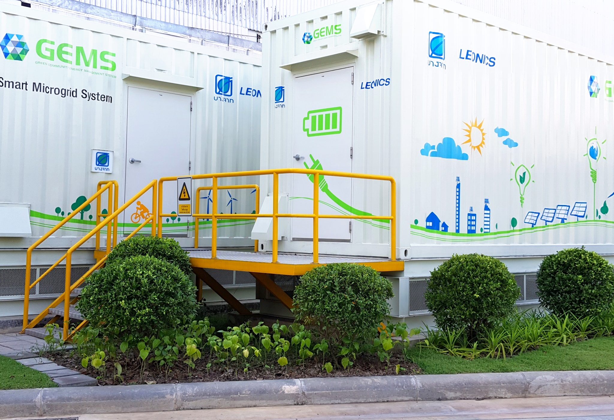 LEONICS GEMS smart microgrid at Bangchak Gas Station, Bangkok — containerized powerhouse holding the 1 MWh lithium battery and controls, with GEMS, Bangchak and LEONICS branding on the containers